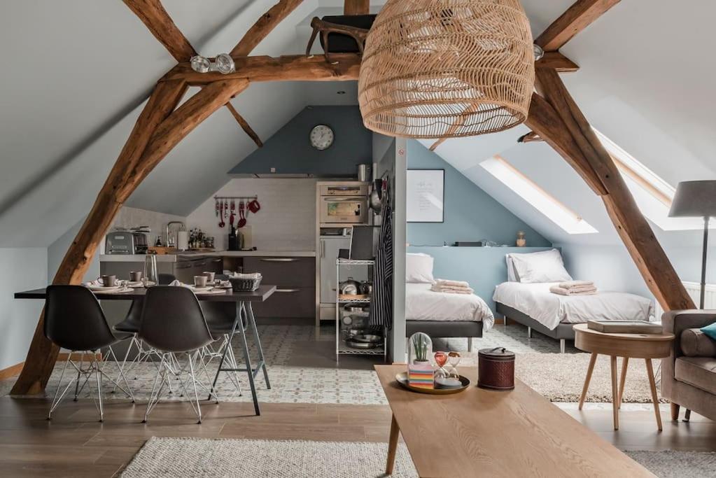 een woonkamer met een loft met een tafel en stoelen bij Van Hamme 1642 - house for 2 to 4 persons in Kortenberg