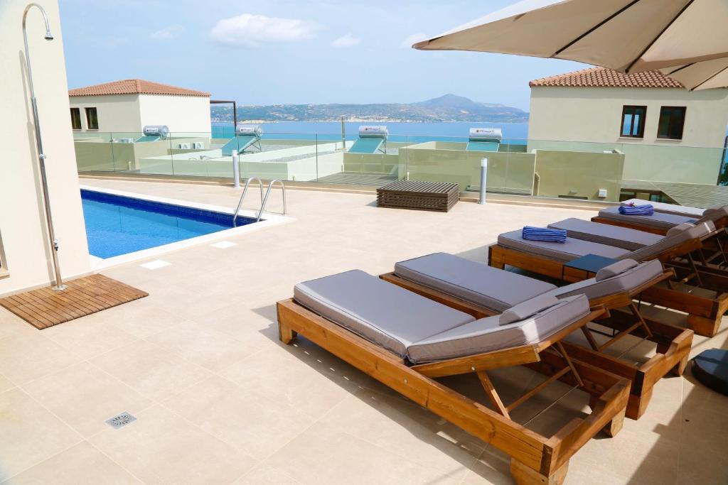 a patio with lounge chairs and a swimming pool at Βίλα -Θαλασσινή αύρα, 500μέτρα από την θάλασσα in Áyios Andónios