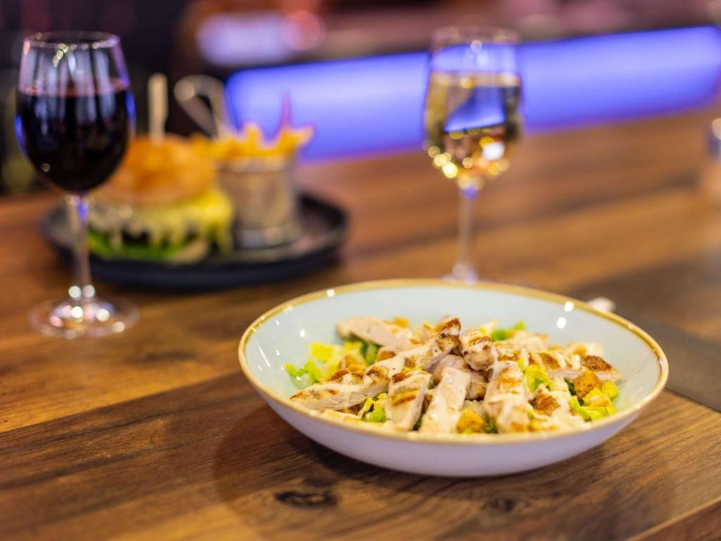 a bowl of food on a table with wine glasses at ibis London City - Shoreditch in London