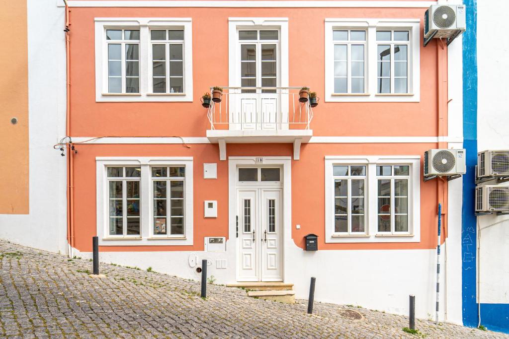 a orange and white house with a balcony at Lost Lobster Guest House in Albufeira