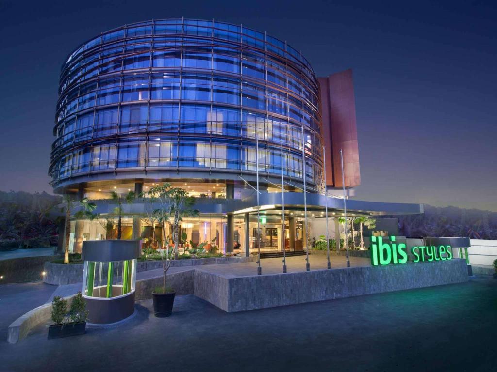 a large glass building with a sign in front of it at Ibis Styles Jakarta Airport in Tangerang