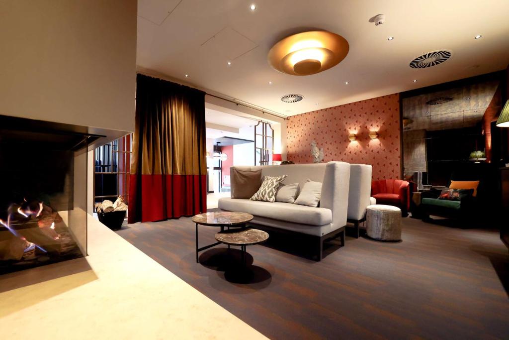 uma sala de estar com um sofá e uma lareira em Best Western Plus Hotel St. Raphael em Hamburgo