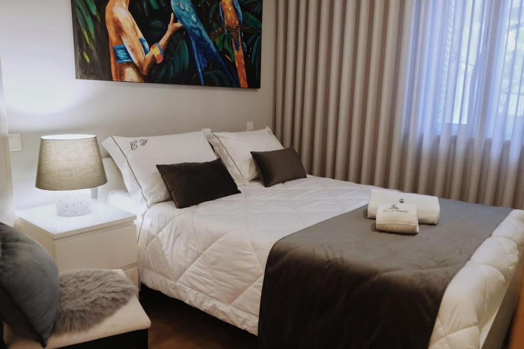 a bedroom with a bed and a table with a lamp at Casa do Fontanario em Viana do Castelo in Viana do Castelo