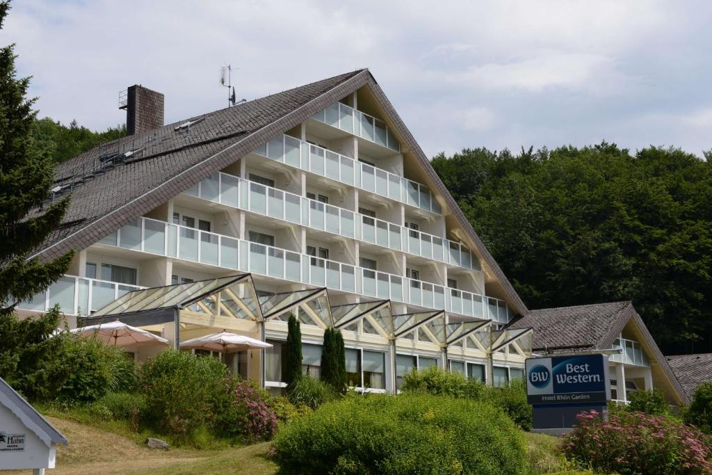 ein großes Gebäude mit einem Schild davor in der Unterkunft Sure Hotel by Best Western Rhoen Garden in Poppenhausen