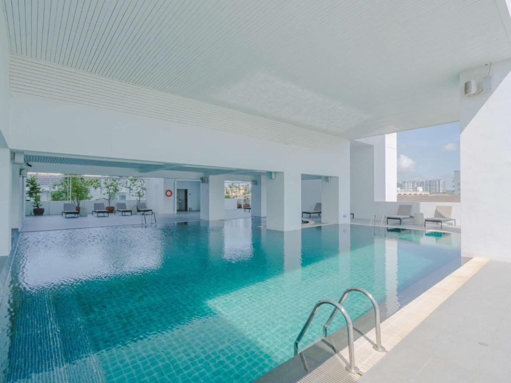 a large swimming pool with blue water in a building at Novotel Phuket City Phokeethra in Phuket Town