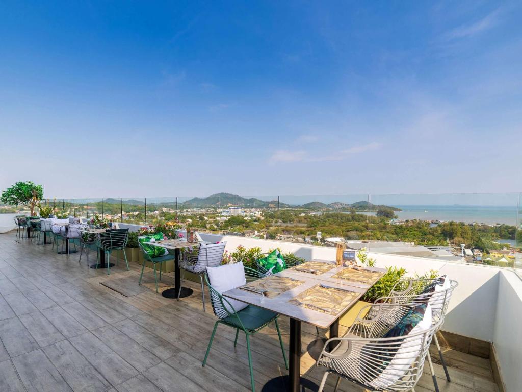 a row of tables and chairs on a balcony at Novotel Phuket City Phokeethra in Phuket Town