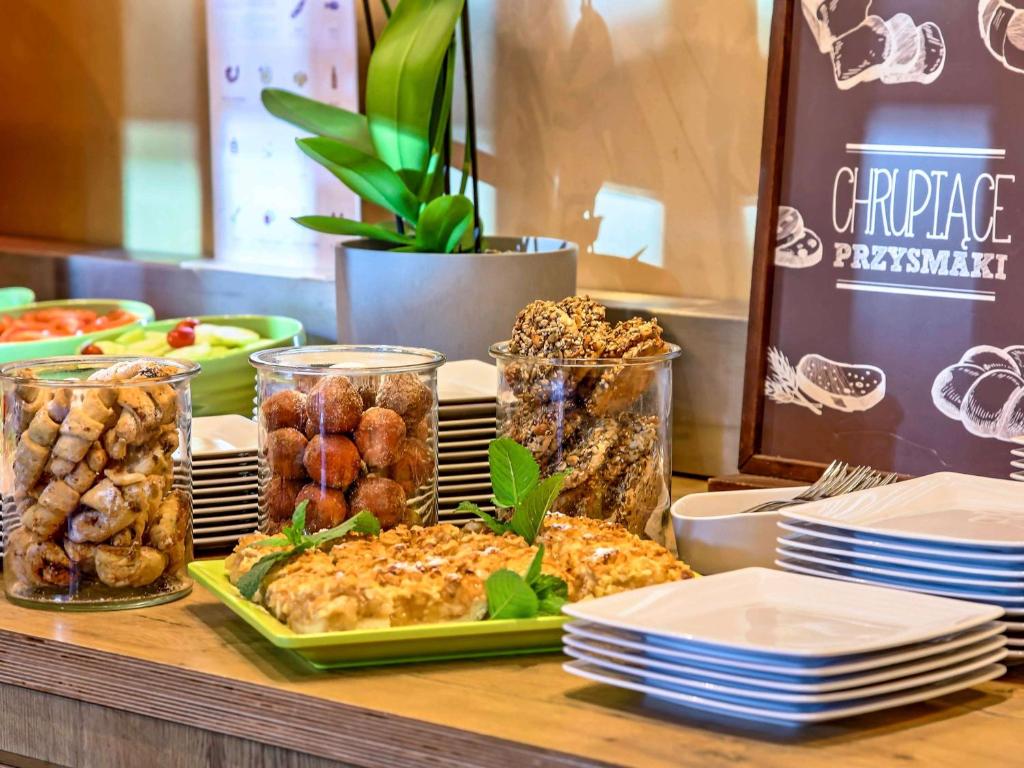 a buffet of food on a table with plates of food at Ibis Gdansk Stare Miasto in Gdańsk