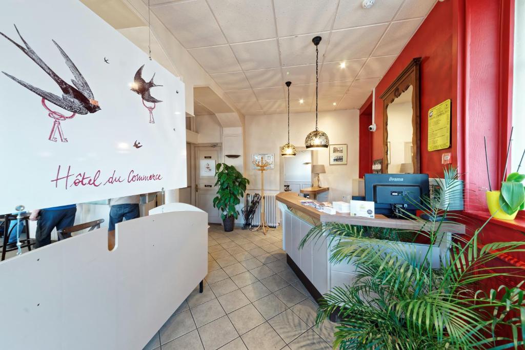 a lobby of a restaurant with a waiting area with a bird on the wall at Contact Hôtel du Commerce et son restaurant Côte à Côte in Autun
