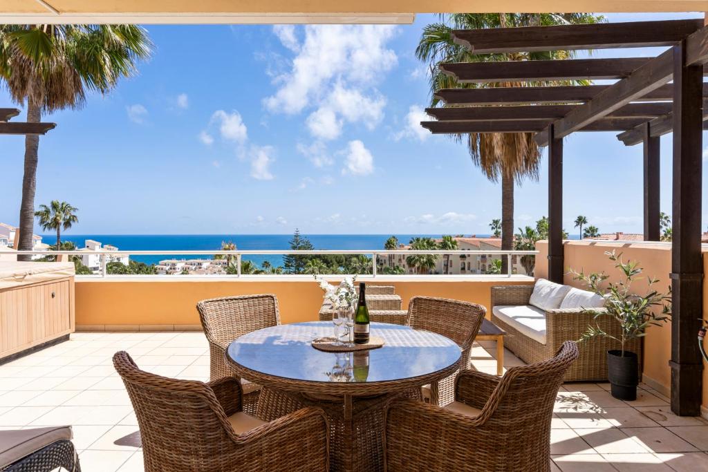 een patio met een tafel en stoelen en de oceaan bij Malibu B3 Luxury 2BR Panoramic Sea View Ref 245 in Fuengirola