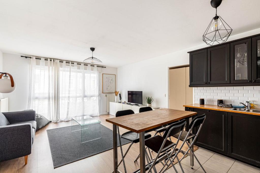 uma cozinha e sala de estar com mesa e cadeiras em GuestReady - Chic Hideaway near Paris em Saint-Ouen