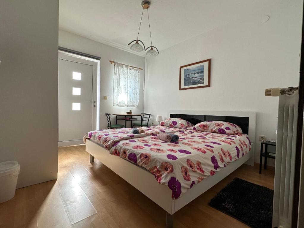 a bedroom with a large bed with a pink comforter at Rooms MARE in Poreč