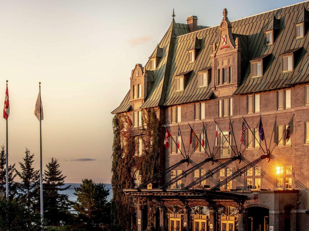 un edificio con banderas delante en Fairmont Le Manoir Richelieu, en La Malbaie