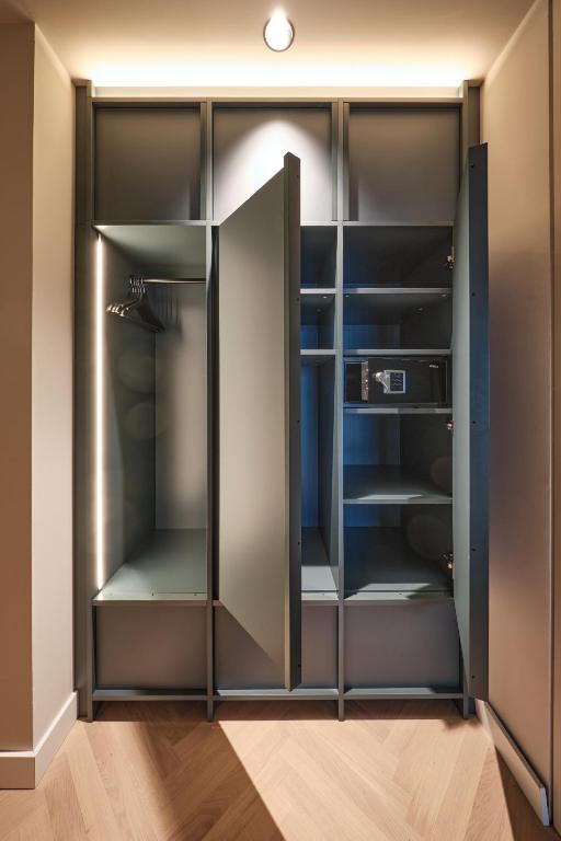 a walk in closet with black glass doors at The Zipper Hotel und Apartments in Düsseldorf