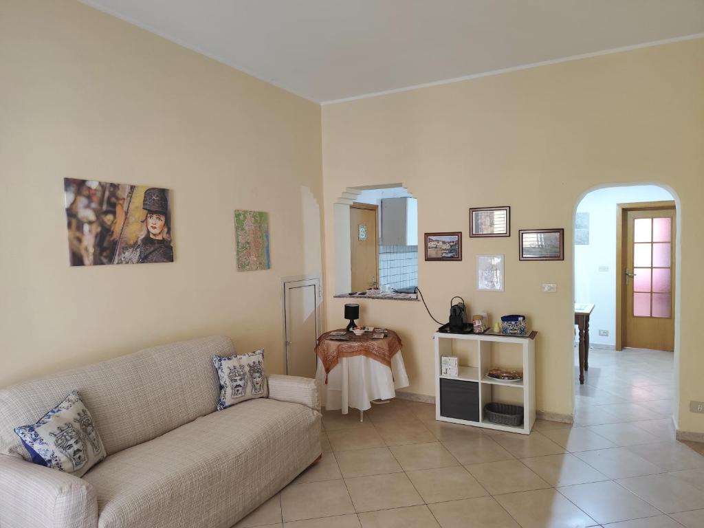 ein Wohnzimmer mit einem Sofa und einem Tisch in der Unterkunft La Casa Di Via Marzulli in Acireale