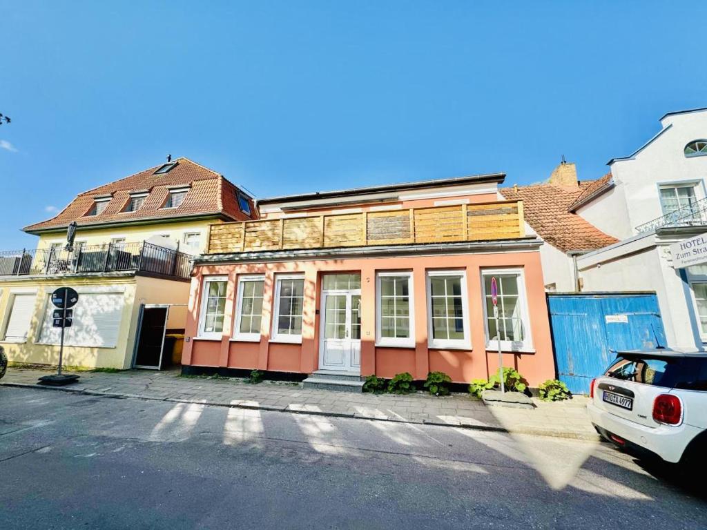 an old house with a wooden roof on a street at Haus seaZEIT, Meerliebe in Warnemünde