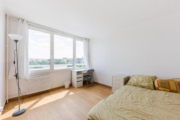 a bedroom with a bed and a large window at Chambre à Créteil in Créteil