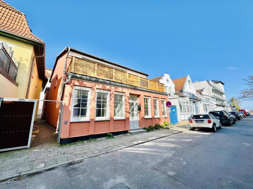 une rangée de maisons dans une rue avec des voitures garées dans l'établissement Haus seaZEIT, Seeliebe, à Warnemünde