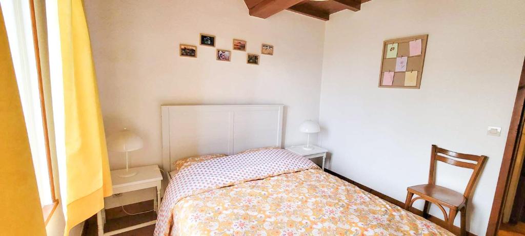 une petite chambre avec un lit et une chaise dans l'établissement La clef des chants, à Longueville