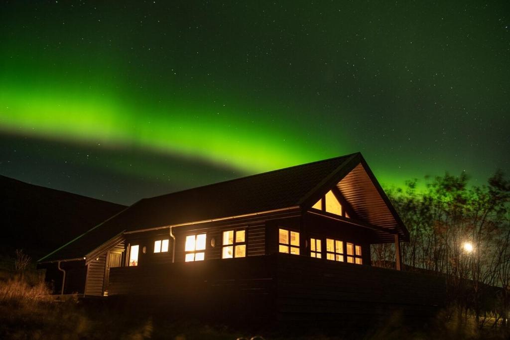 an image of a house with the aurora in the sky at Geysir Cabins - Golden Circle Cabin only 800m from Geysir in Selfoss