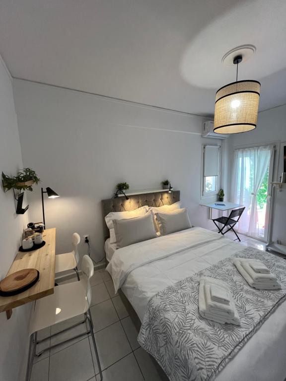 1 Schlafzimmer mit 2 Betten, einem Tisch und einem Schreibtisch in der Unterkunft Para Thin Alos in Peraia