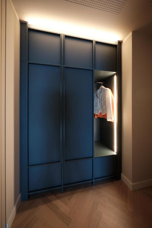 a wardrobe with blue doors in a room at The Zipper Hotel und Apartments in Düsseldorf