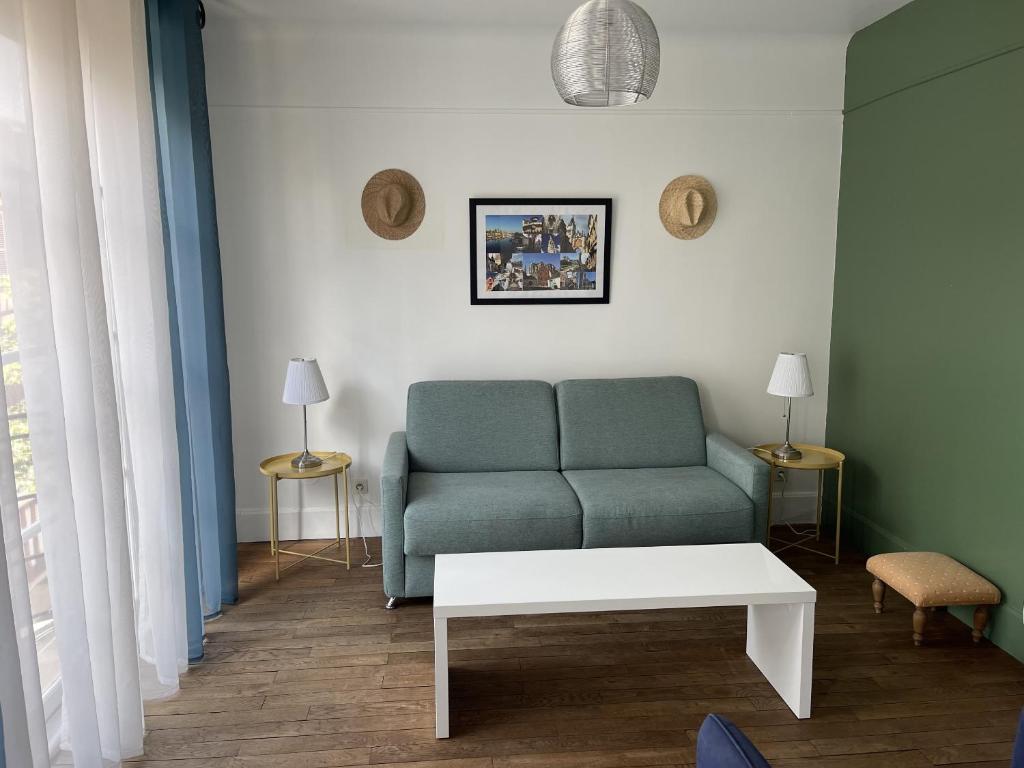 a living room with a couch and a table at Appartement Le Temple Auxerre Centre Ville in Auxerre