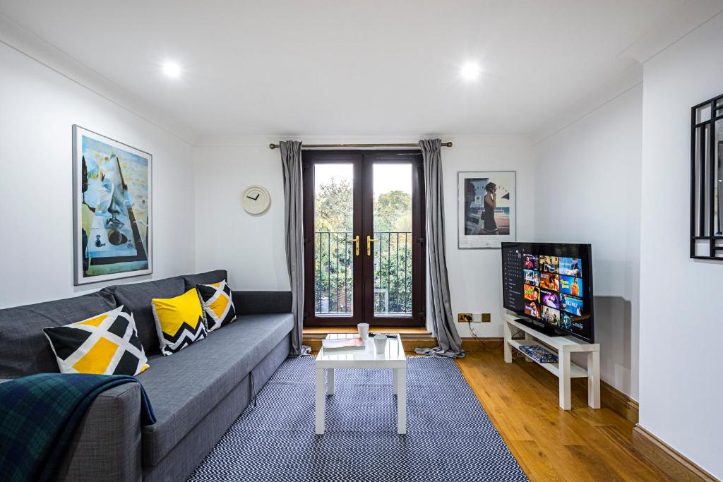 2 Bedroom Apartment by AV Stays Short Lets Southwark London With Free WiFi في لندن: غرفة معيشة مع أريكة وتلفزيون