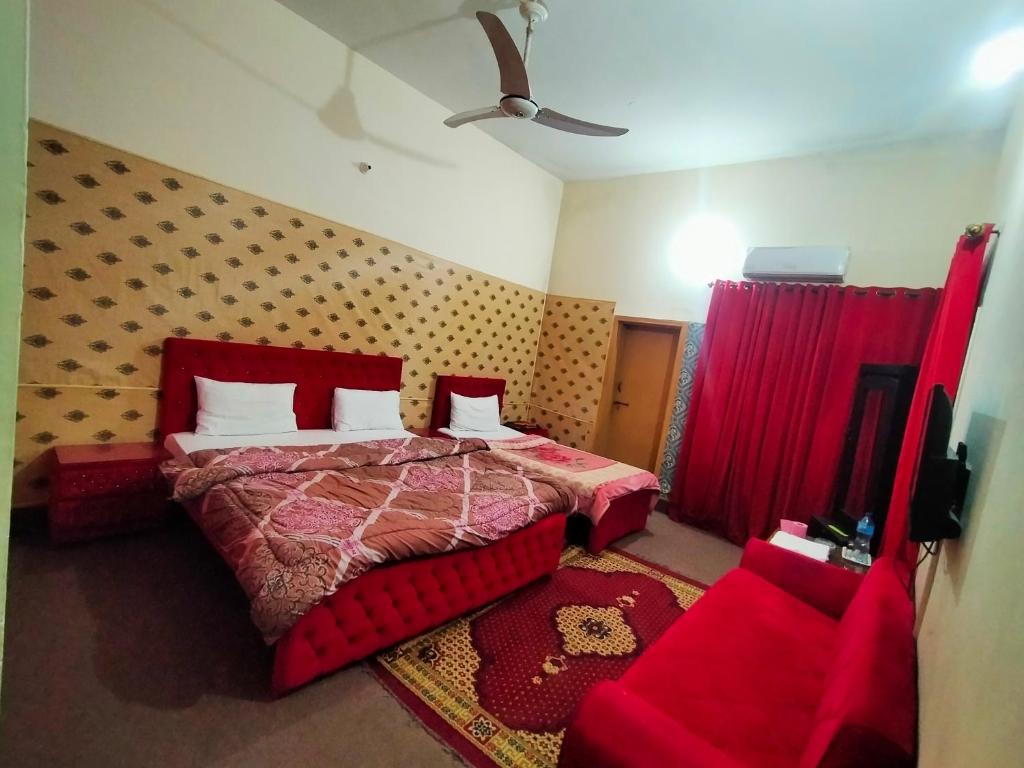 a bedroom with a red bed and red curtains at Peridot Cottage in Islamabad