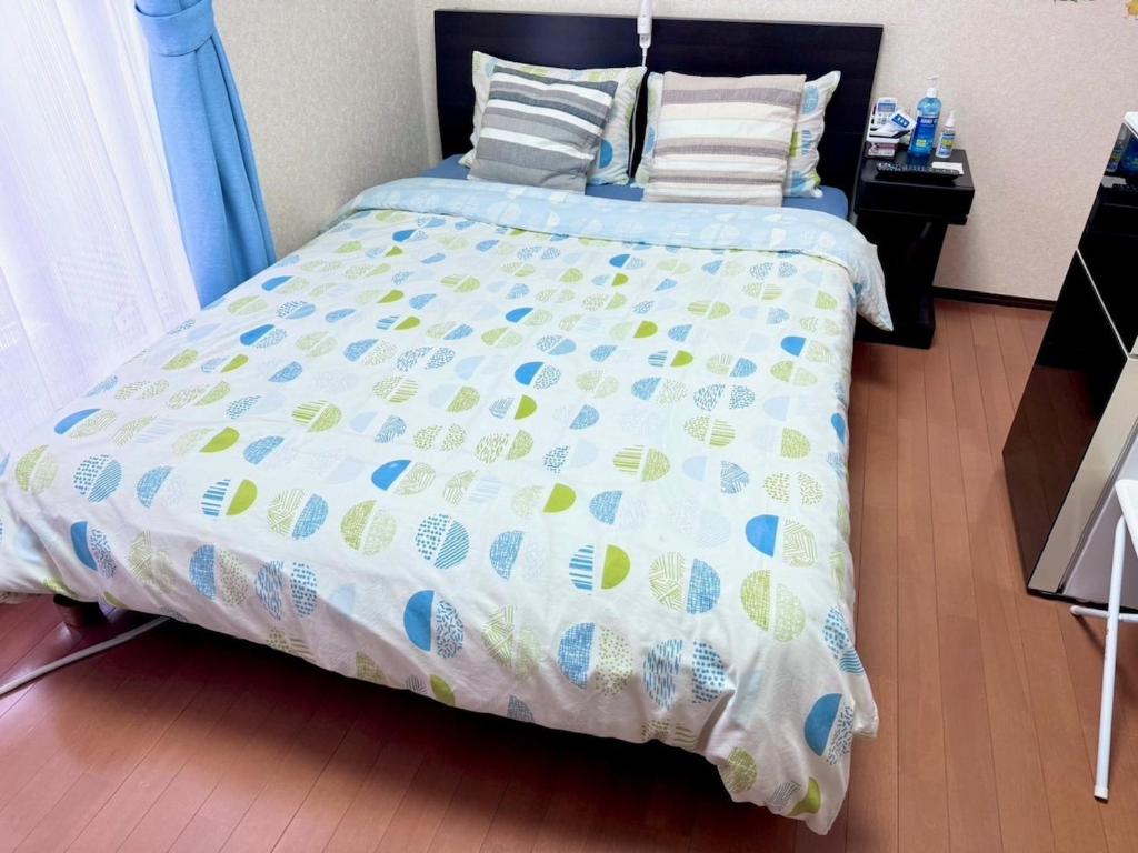 浦安的住宿－Grandeur Imagawa - Vacation STAY 11149，卧室内的一张带蓝色和白色棉被的床
