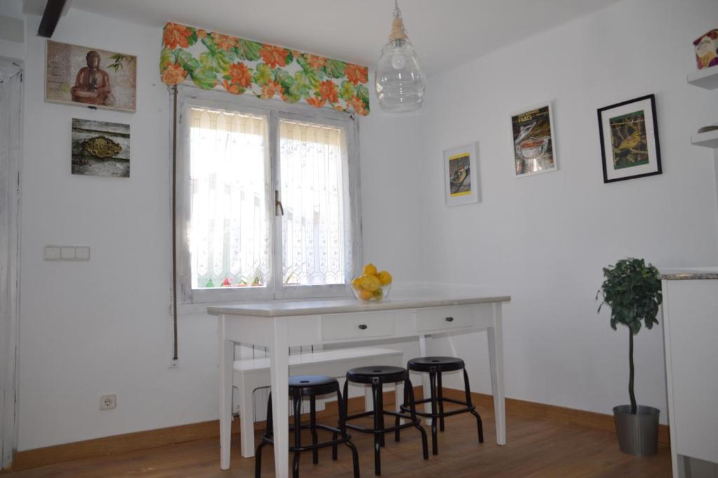 a kitchen with a white table and stools at MyHouseSpain Casa Pepe Pastora in Castiello de la Marina