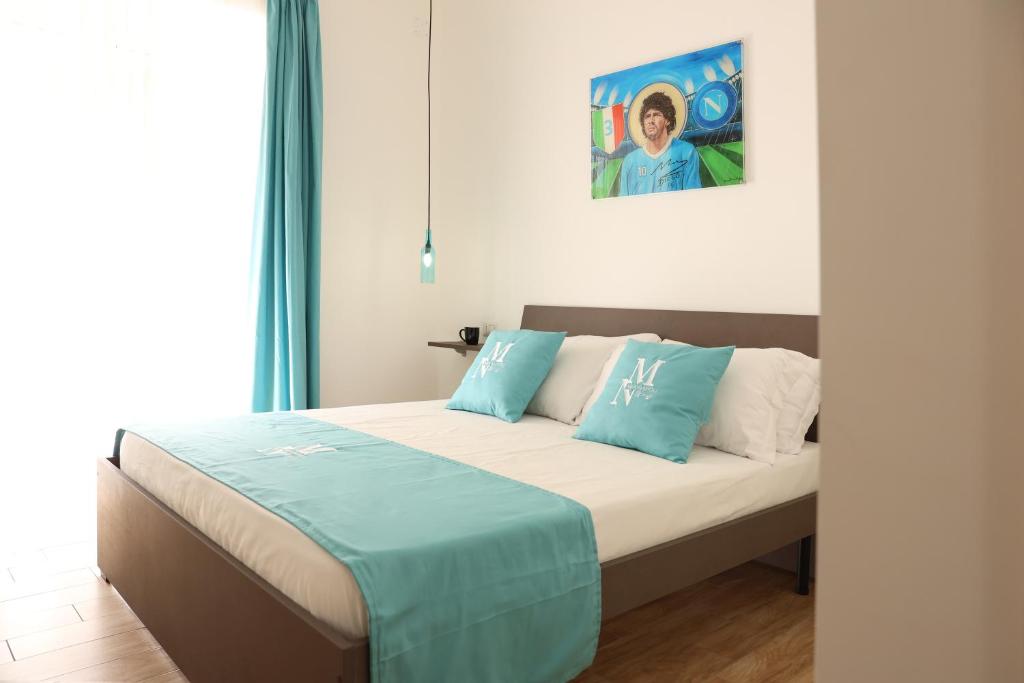 een slaapkamer met een bed met blauwe en witte kussens bij Mia Napoli in Napels