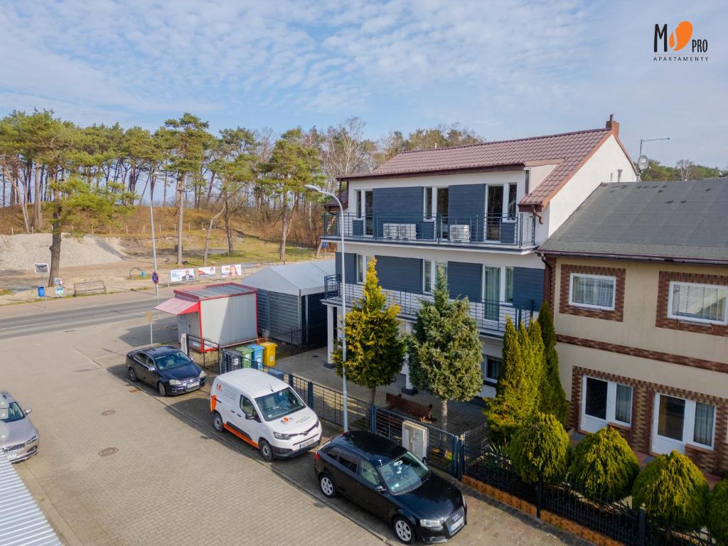 an aerial view of a house with cars parked in a parking lot at Dom Wakacyjny MS Pro w Dźwirzynie in Dźwirzyno