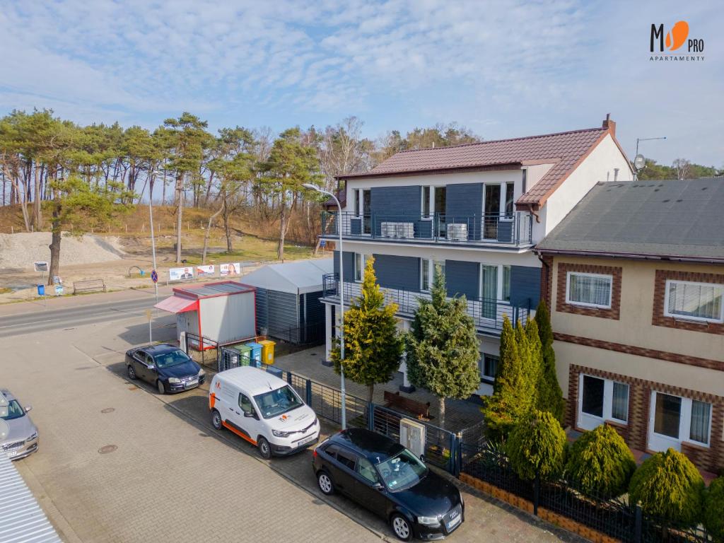 una vista aerea di una casa con auto parcheggiate in un parcheggio di Dom Wakacyjny MS Pro w Dźwirzynie a Dźwirzyno