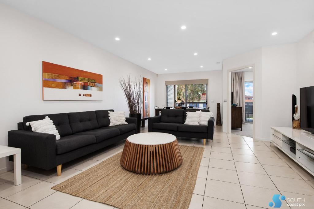 a living room with a couch and a table at Batemans Bay Apartment in Batemans Bay