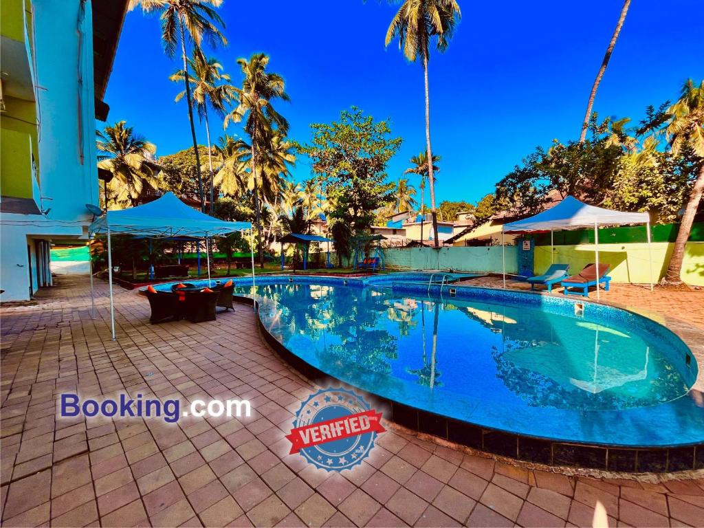 einen Pool in einem Resort mit Palmen in der Unterkunft Hotel in GOA With Swimming Pool ,Managed By The Four Season - Close to Baga Beach in Goa