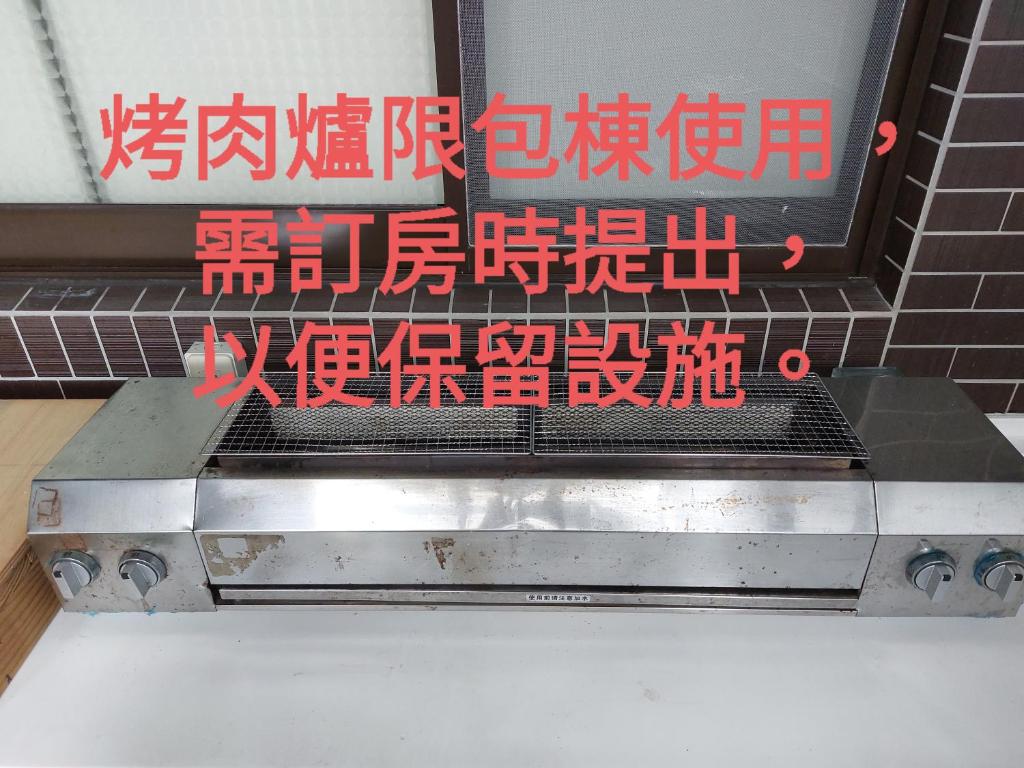 a sign with chinese writing on the side of a grill at Field Trail Homestay in Jiaoxi