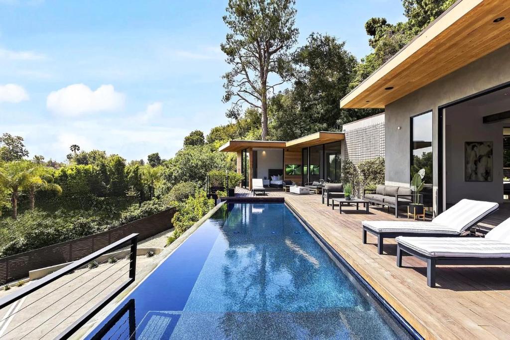 una piscina all'aperto con sedie e una casa di Stunning 5 Bedroom Villa with Private Pool a Los Angeles