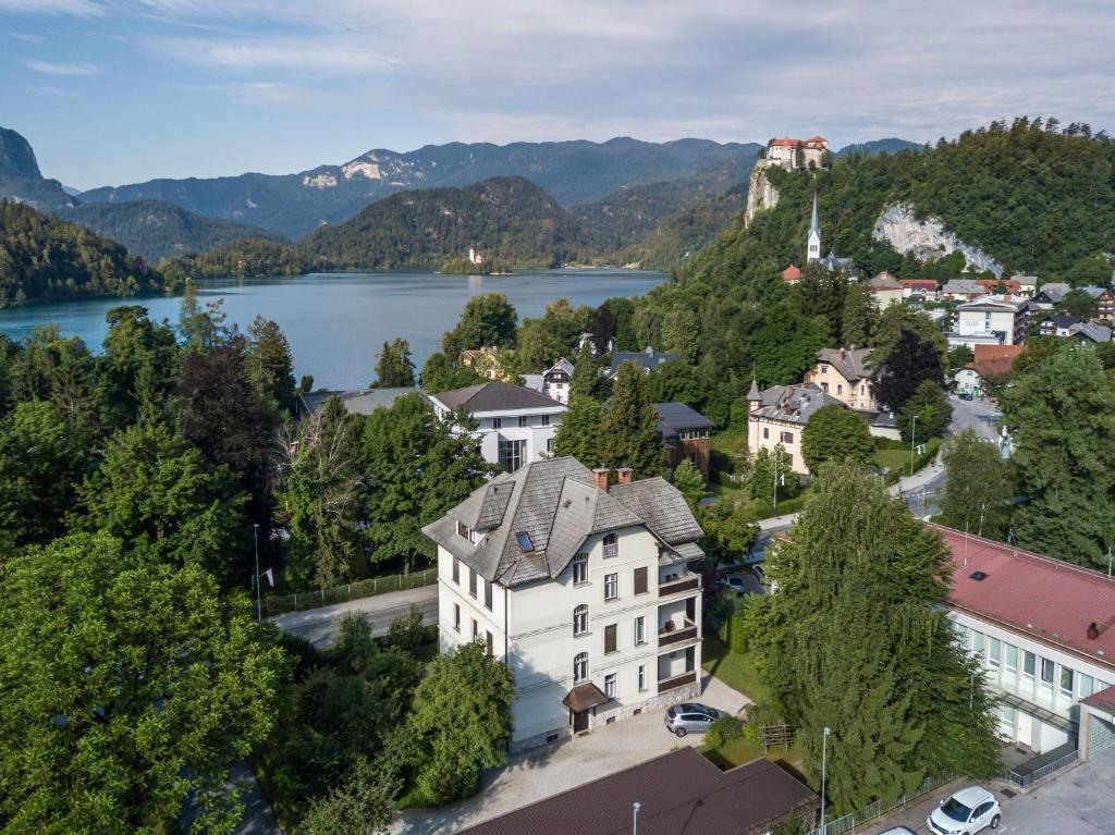 布萊德的住宿－Cozy apartments in an authentic villa near the lake Bled and the castle，享有湖泊和山脉小镇的空中景致