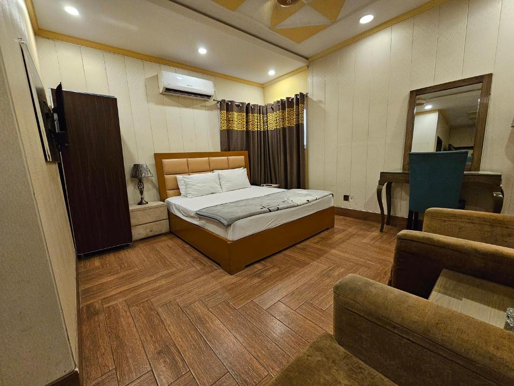 1 dormitorio con 1 cama y 1 sofá en Xpress Hotel en Lahore