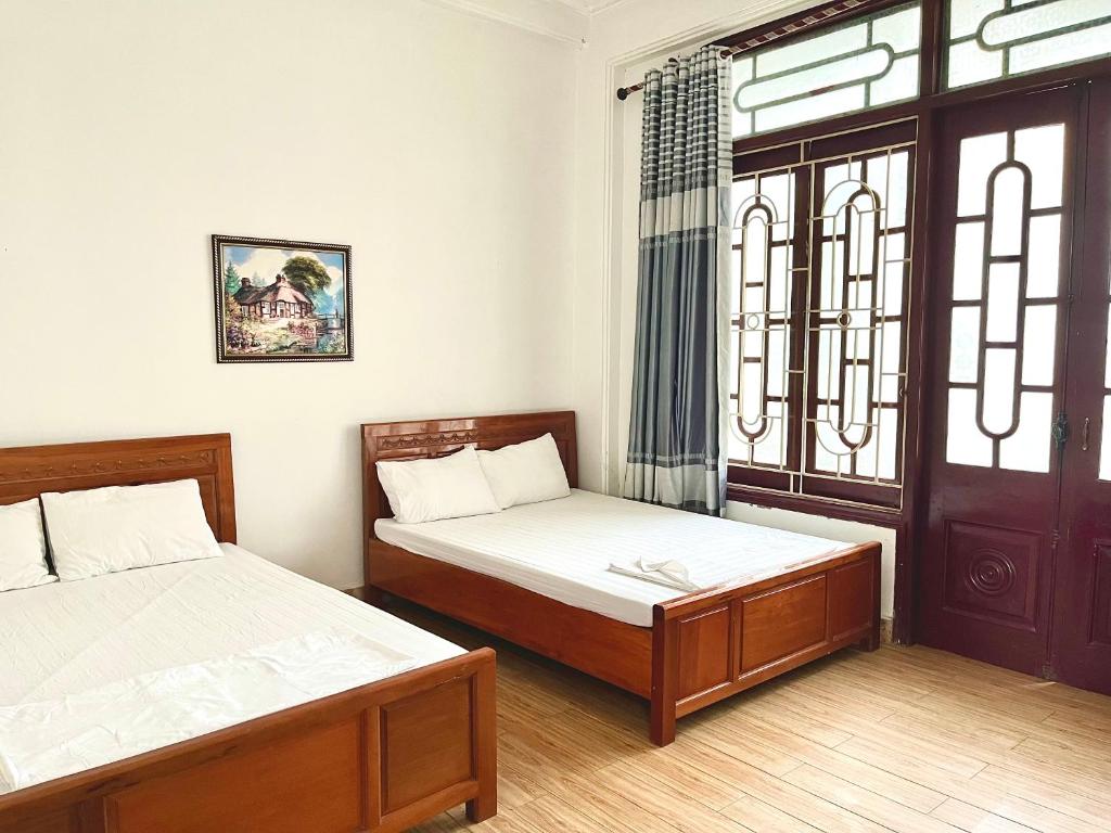 2 camas en una habitación con ventana en Sofia Tống Duy Tân, en Sầm Sơn