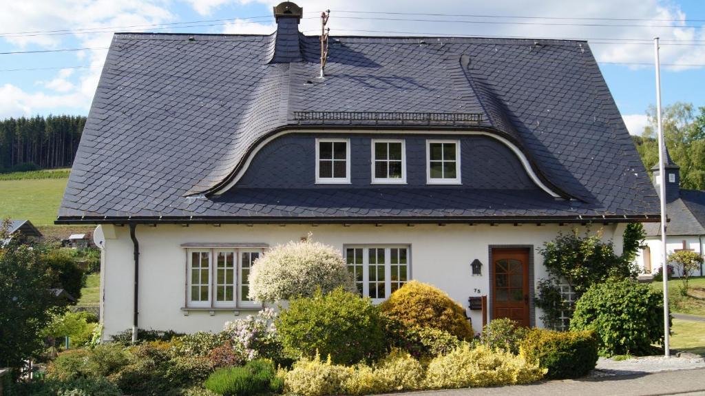 una casa blanca con techo negro en Ferienwohnung Kebben en Kirchhundem