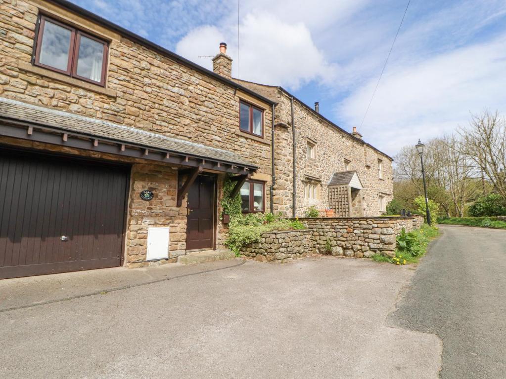 a brick house with a garage and a driveway at Barn Cottage in Carnforth