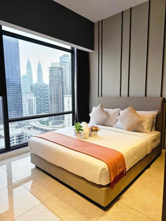 a bedroom with a large bed with a large window at Maxx Royal Suites at Axon Kuala Lumpur in Kuala Lumpur