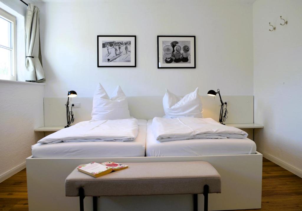 two beds with white pillows and a table in a room at Insel Landhaus Seaside in Gager