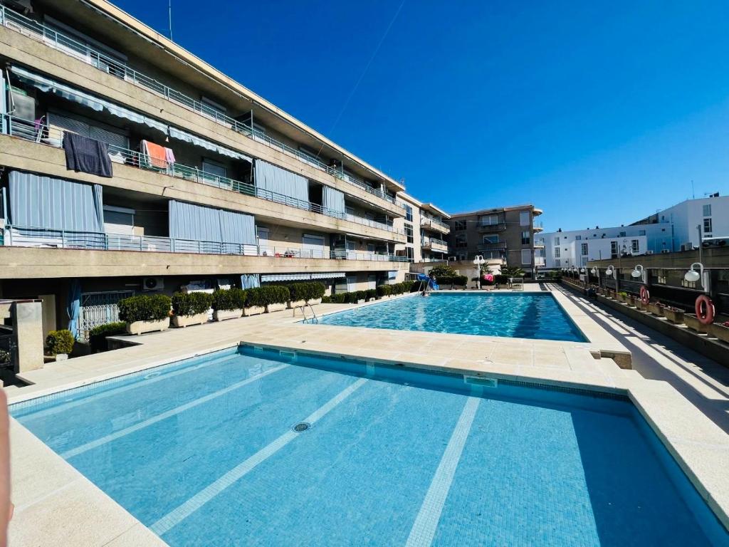 a large swimming pool in front of a building at Apartamento Salvis Balcón in Platja d'Aro