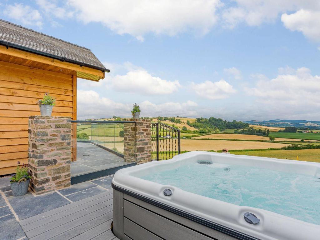 a hot tub on the deck of a house at 3 Bed in Montgomery 88641 in Llandyssil
