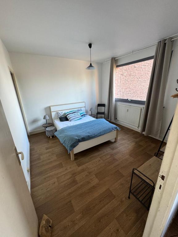 - une chambre avec un lit et une grande fenêtre dans l'établissement Rijsel Vlamse, à Lille