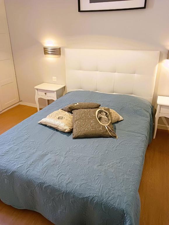 - une chambre avec un lit bleu et 2 tables de nuit dans l'établissement LA MARMOTTE appartement T2 classé 3 étoiles, à Aulus-les-Bains
