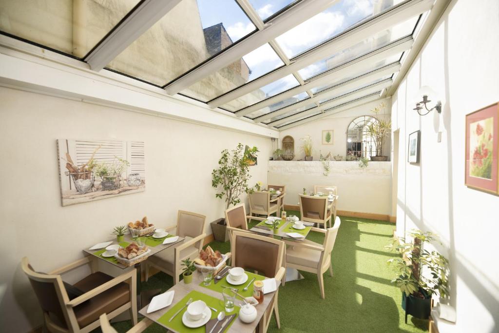a dining room with tables and chairs and a skylight at Hotel d'Aragon - Place de la Comédie in Montpellier