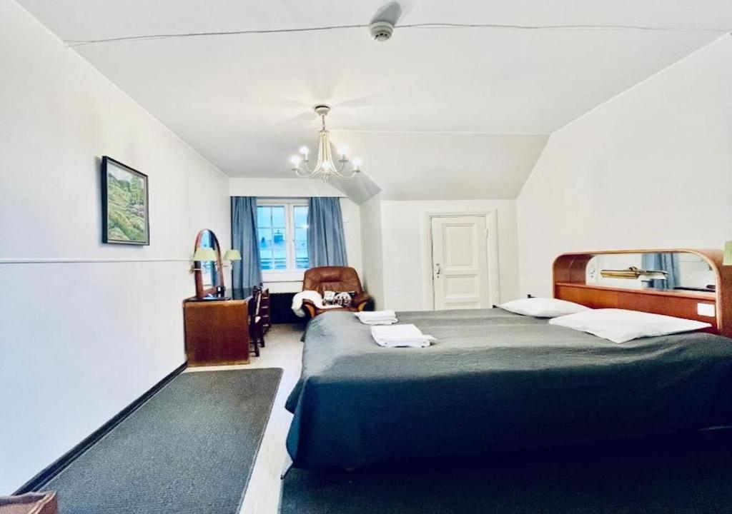 a bedroom with a large bed and a chair at Senate Hotel in Helsinki